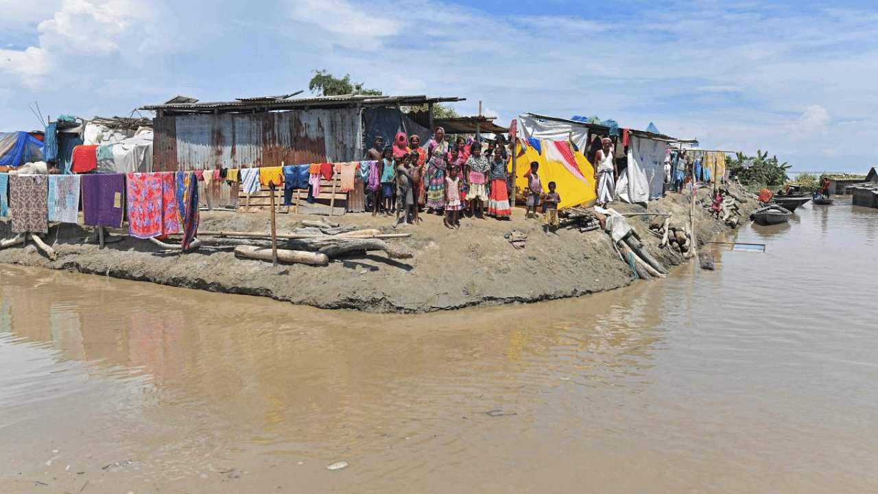 Villagers take shelter on higher grounds in a flood affected area of Morigaon district in Assam. Credit: AFP Photo