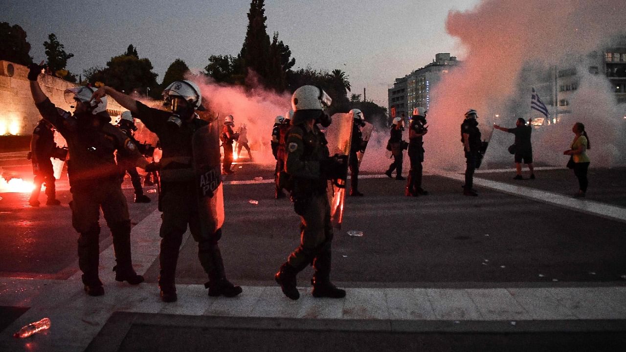 Police use tear gas to disperse thousands of protesters in Athens' Syntagma Square opposing the government's plan for mandatory vaccination by health workers against the Covid-19 virus, on August 29, 2021. Credit: AFP Photo
