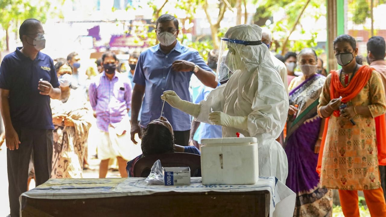 Health care worker takes swab sample for Covid-19 testing in Kozhikode. Credit: PTI Photo