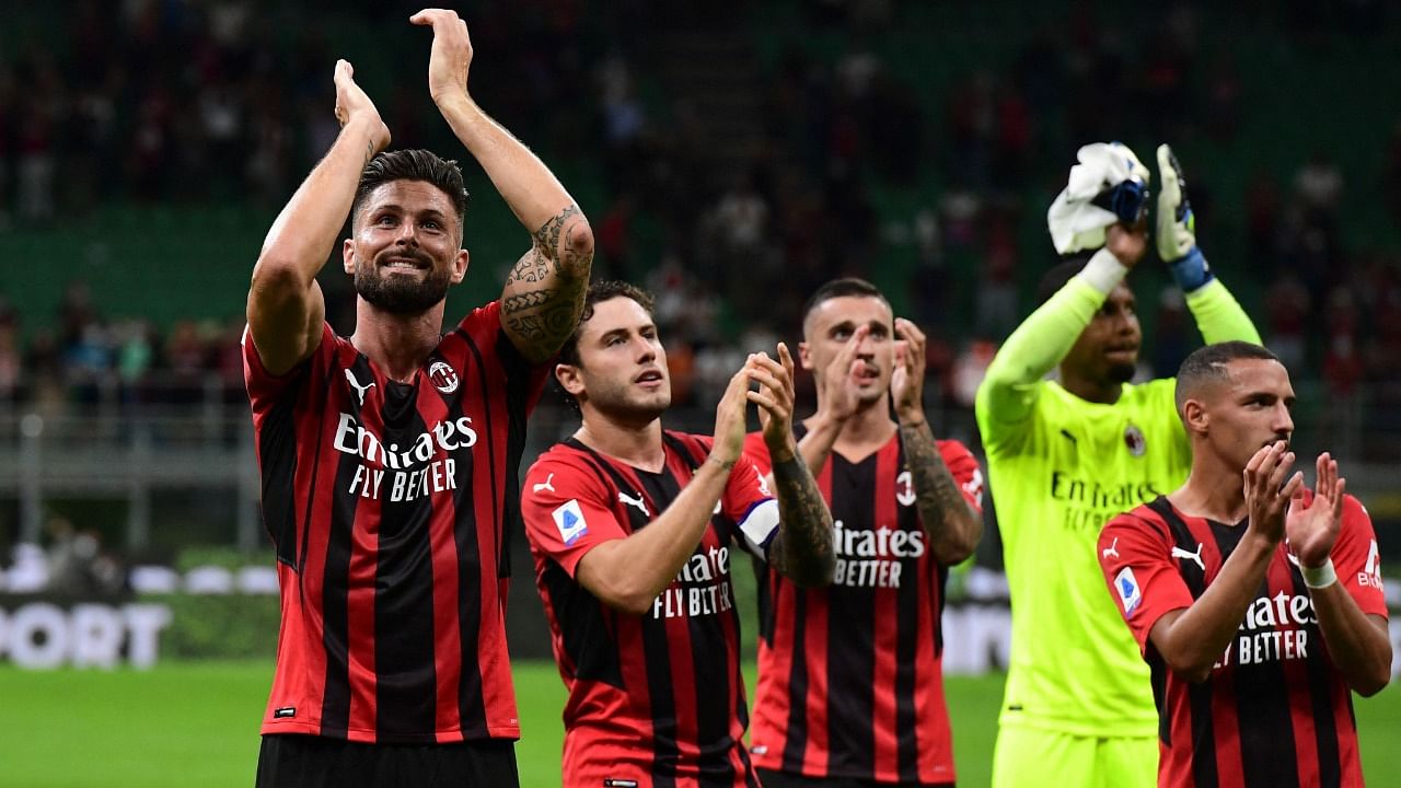 AC Milan's French forward Olivier Giroud (L) and teammates celebrate at the end of the Italian Serie A football match between AC Milan and Cagliari at the San Siro stadium in Milan. Credit: AFP Photo