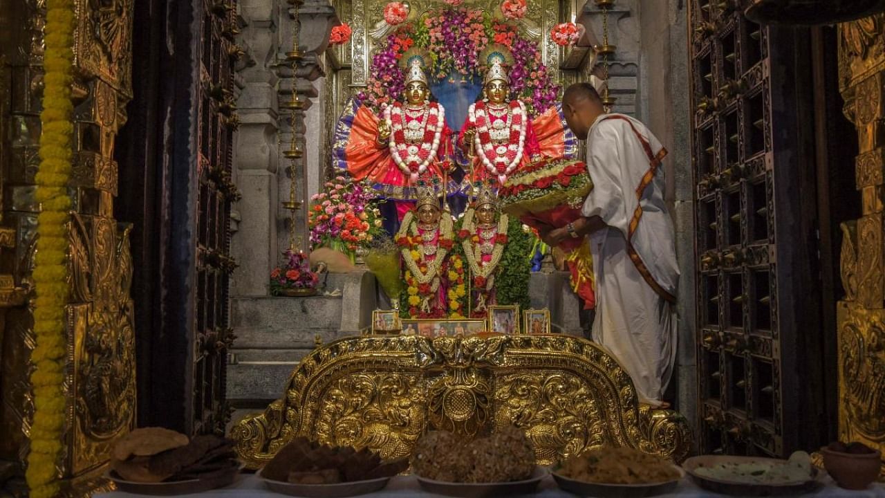 A Hindu priest performs a ritual in front of idols of Hindu god Krishna and Balarama on the occasion of 'Janmashtami' festival that marks the birth of Krishna, at a temple in Bangalore on August 30, 2021. Credit: AFP Photo