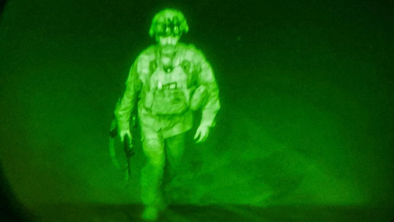US Army Major General Chris Donahue, commander of the 82nd Airborne Division, steps on board a C-17 transport plane as the last U.S. service member to leave Hamid Karzai International Airport in Kabul, Afghanistan August 30, 2021 in a photograph taken using night vision optics. Credit: Reuters Photo