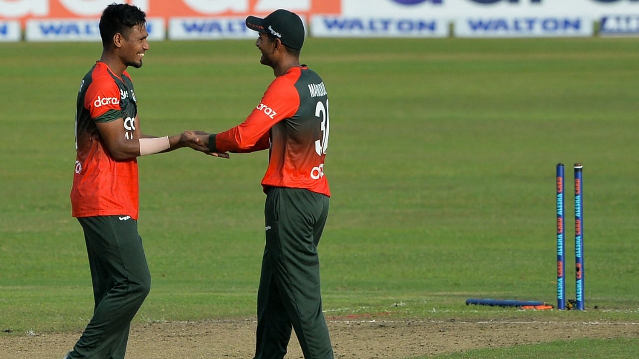 Bangladesh's Mustafizur Rahman (L) celebrates with teammate Mahmudullah after the dismissal of New Zealand's Ajaz Patel. Credit: AFP Photo