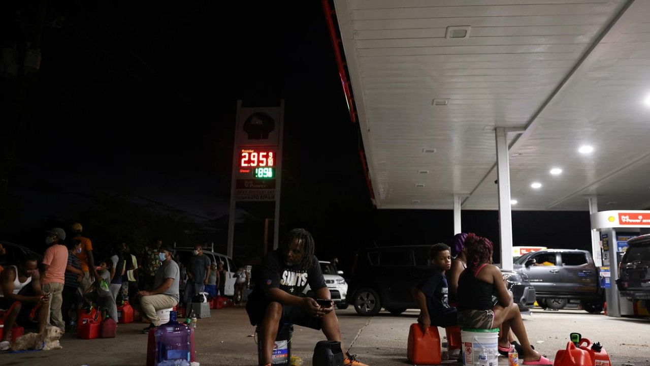 People who say they have been waiting for hours for a gas truck to show up sit at a gas station in the aftermath of Hurricane Ida in New Orleans, Louisiana. Credit: Reuters Photo