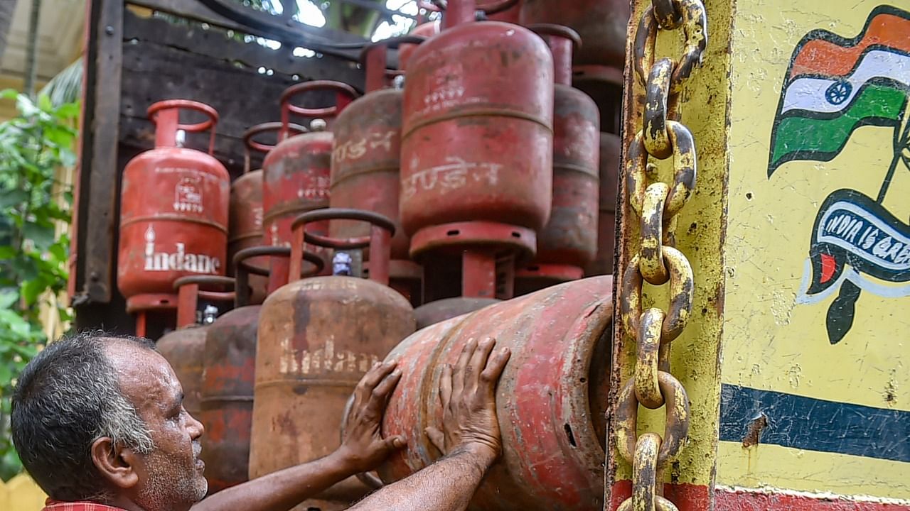 A worker loads an empty LPG gas cylinder in a truck. Credit: PTI Photo