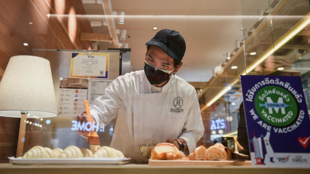 A staff member prepares to open a restaurant on the first day of coronavirus restrictions lift on retail and dining in Bangkok and other high-risk areas to revive the economy, as the country battles its worst Covid-19 outbreak. Credit: Reuters file photo