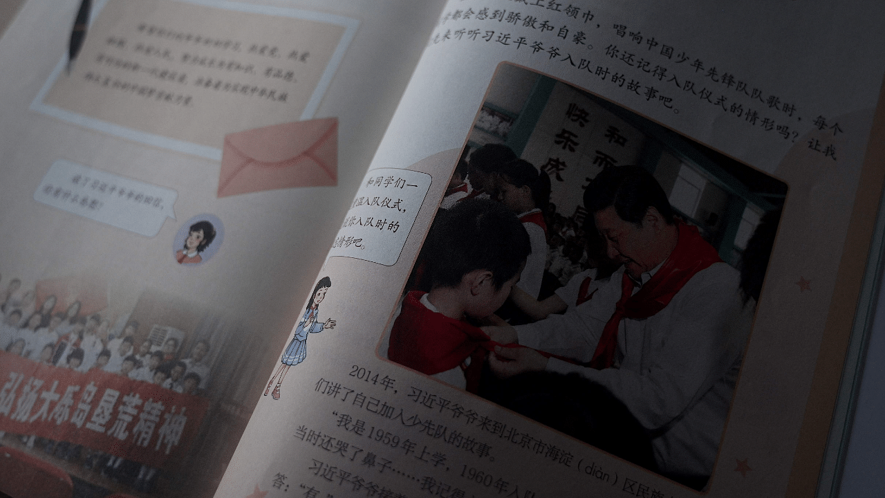 A primary school textbook features photographs and quotes from China's President Xi Jinping. Credit: AFP Photo