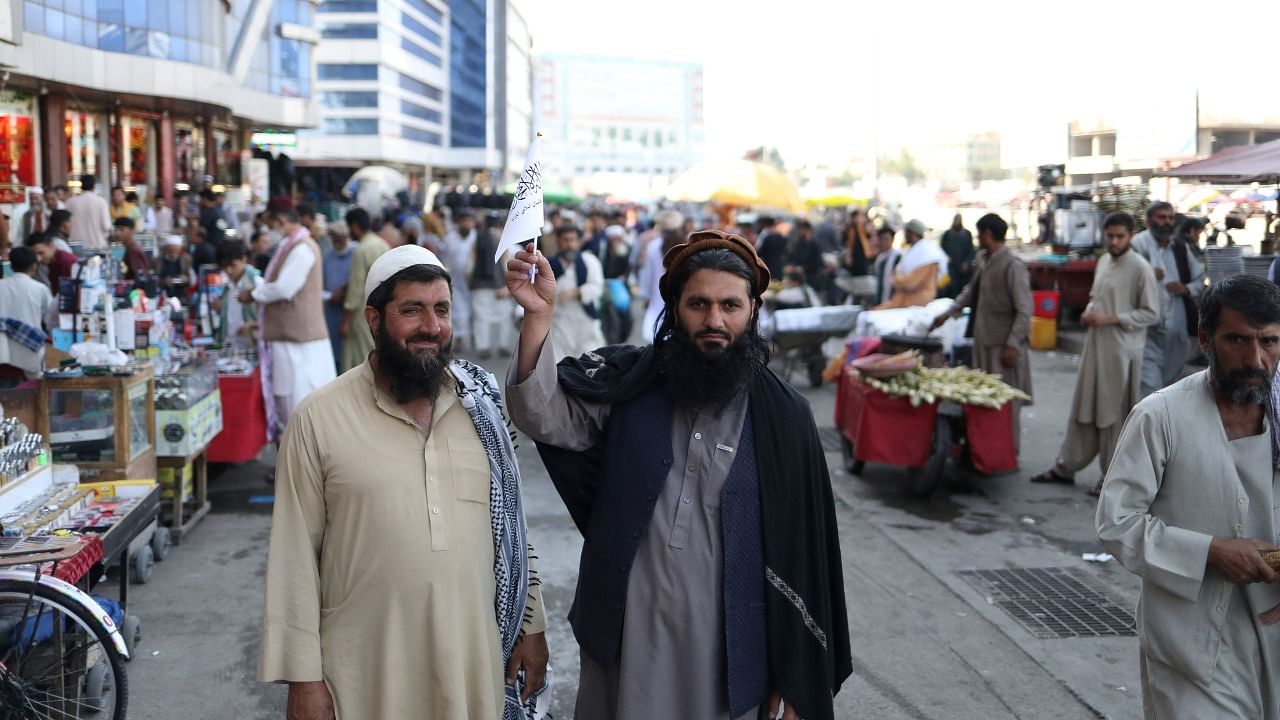 A supporter of the Islamic Emirate of Afghanistan displays the flag of the Taliban in Kabul, Afghanistan, September 1, 2021. Credit: WANA (West Asia News Agency) via Reuters