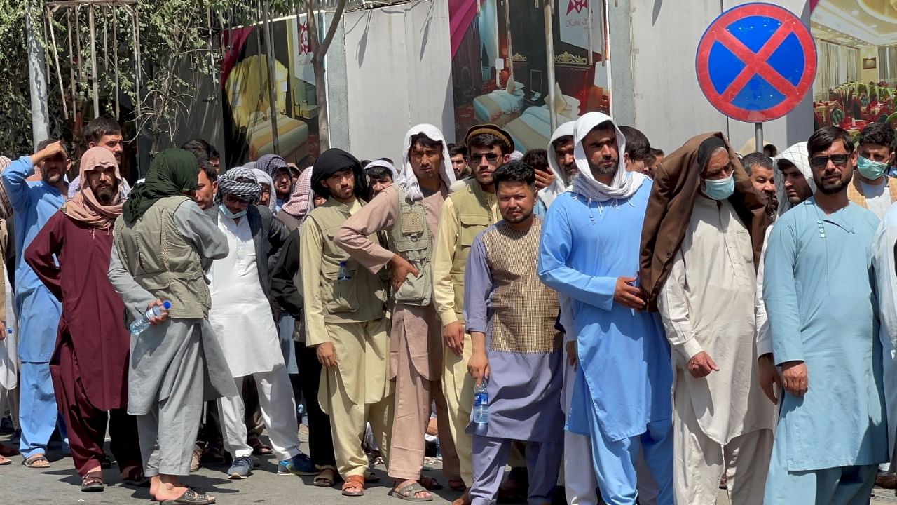 Afghans line up outside a bank. Credit: Reuters Photo