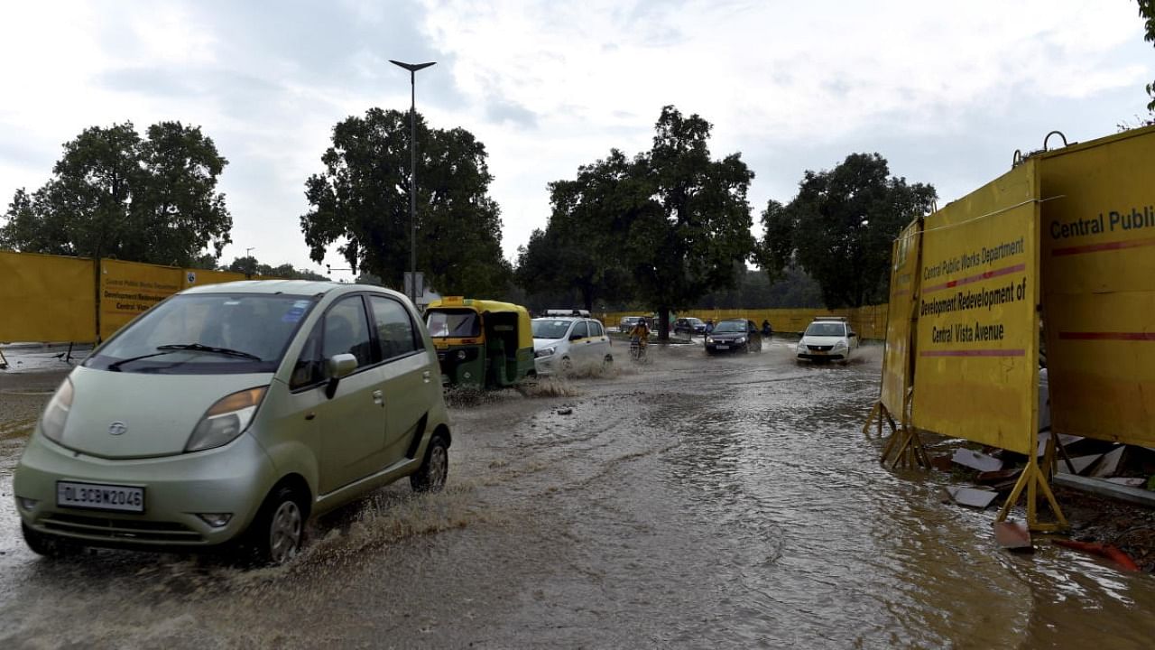 Vehicles ply on a waterlogged road near the India Gate during rains, in New Delhi. Credit: PTI Photo