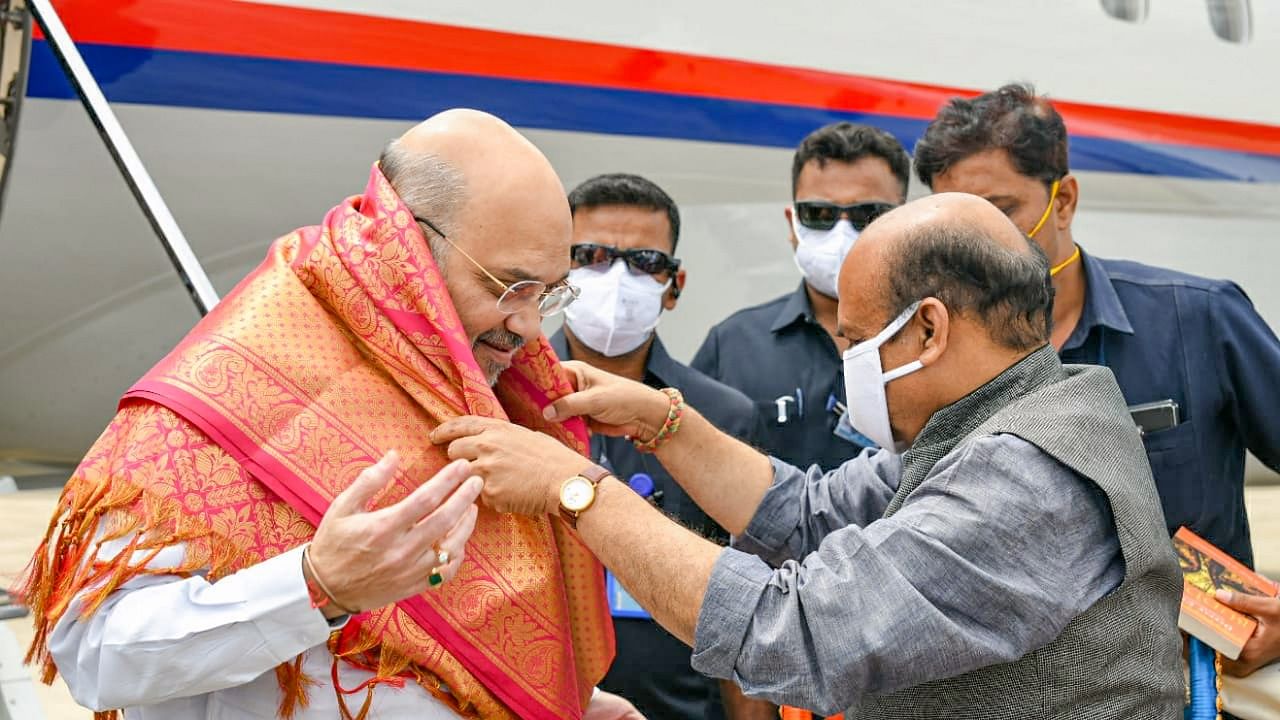 Bommai (R) welcomes Shah at Hubbali airport. Credit: PTI Photo