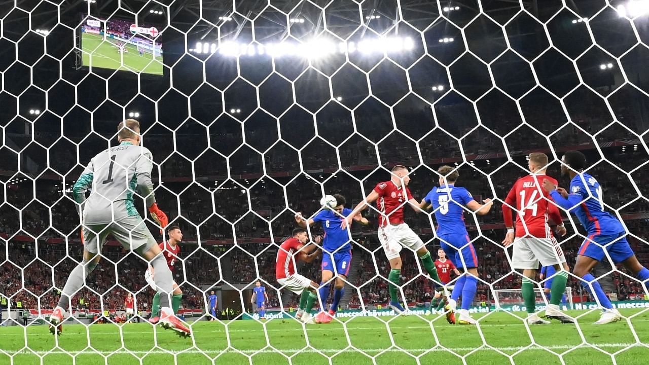 England's defender Harry Maguire (6) heads a score against Hungarian goalkeeper Peter Gulacsi (L) during the FIFA World Cup Qatar 2022 qualification. Credit: AFP Photo