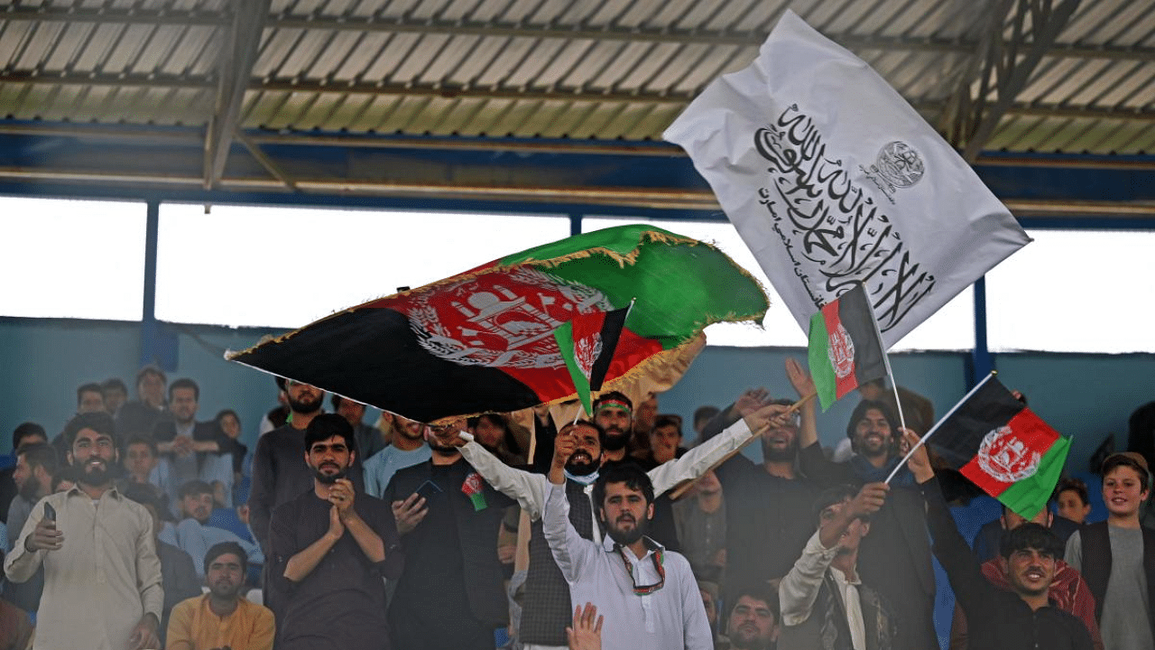 Spectators wave Afghanistan's and Taliban flags as they watch the Twenty20 cricket trial match being played between two Afghan teams 'Peace Defenders' and 'Peace Heroes' at the Kabul International Cricket Stadium in Kabul. Credit: AFP Photo
