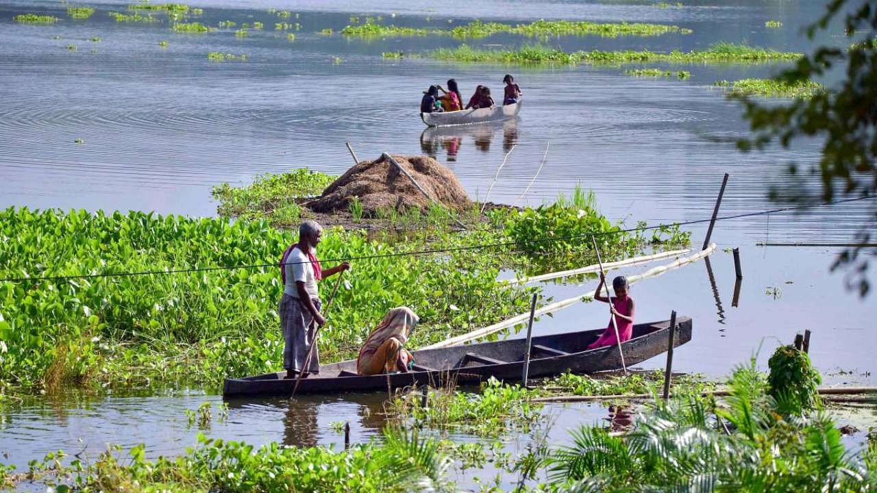 Villagers use boats to move to cross a flooded area near Kaziranga in Golaghat district. Credit: PTI Photo