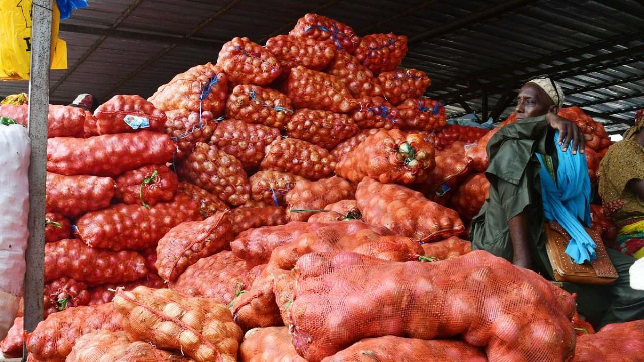 An onion farmer sits on his produce at the Notto Gouye Diama market, one of the main markets for agricultural products in the Thies region. Credit: AFP Photo
