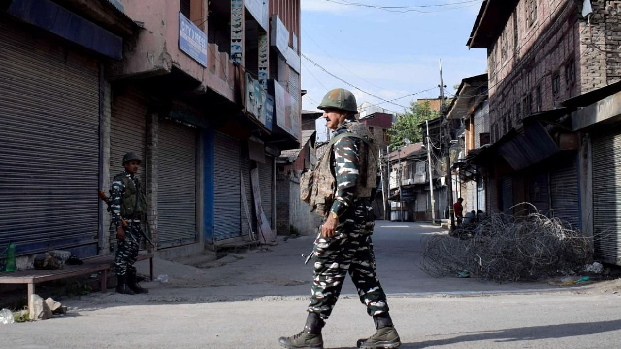 Indian security forces personnel stand guard in front of closed shops during restrictions imposed by authorities following the death of Syed Ali Shah Geelani in Srinagar. Credit: Reuters Photo