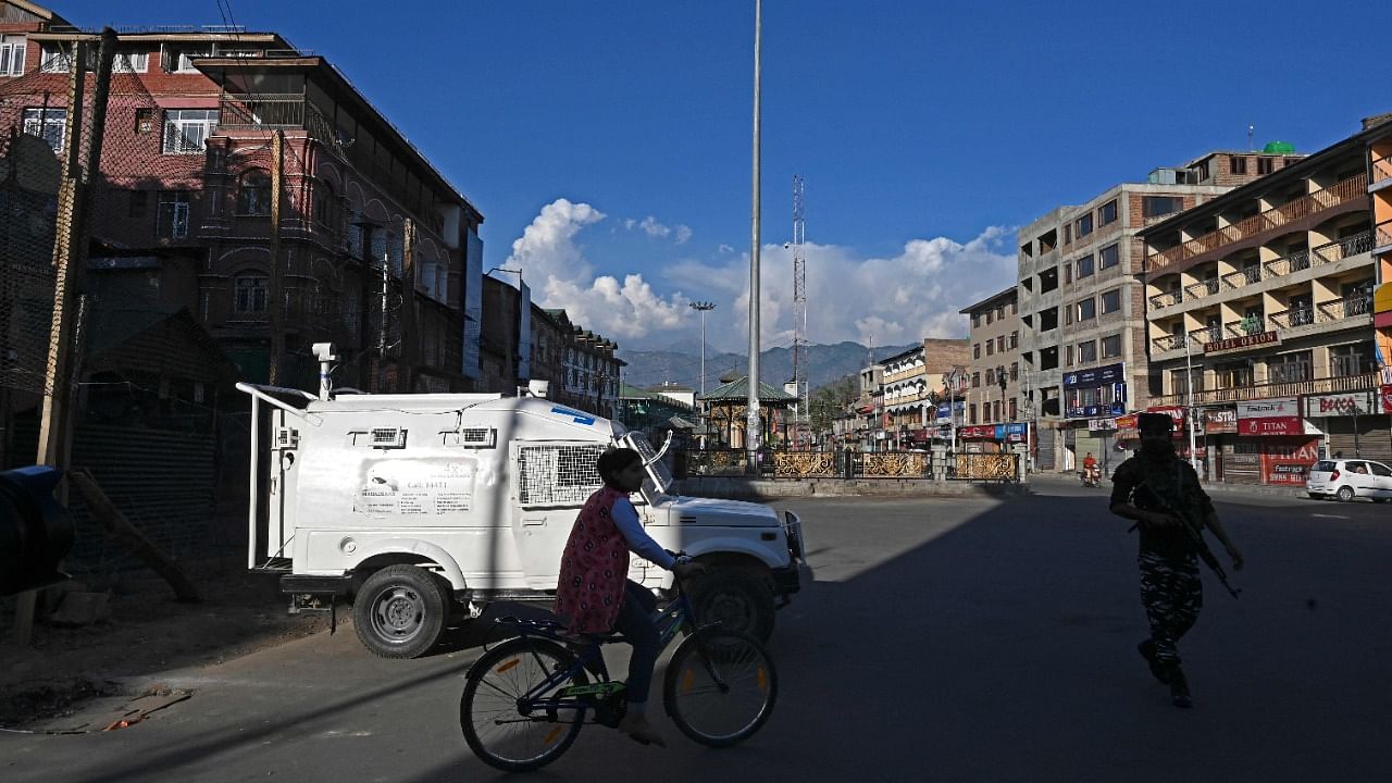 A girl rides a bicycle through a closed market area in Srinagar as security forces maintained a lockdown across Kashmir after the death of a separatist Syed Ali Geelani. Credit: AFP Photo