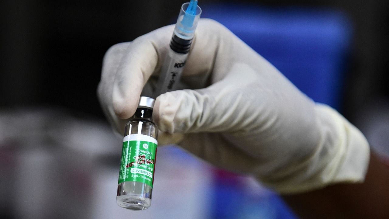 A medical worker holds a vial of the Covishield vaccine. Credit: AFP photo