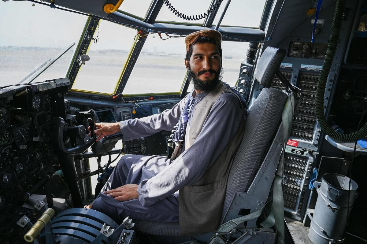 A Taliban fighter sits in the cockpit of an Afghan Air Force aircraft at the airport in Kabul. AFP