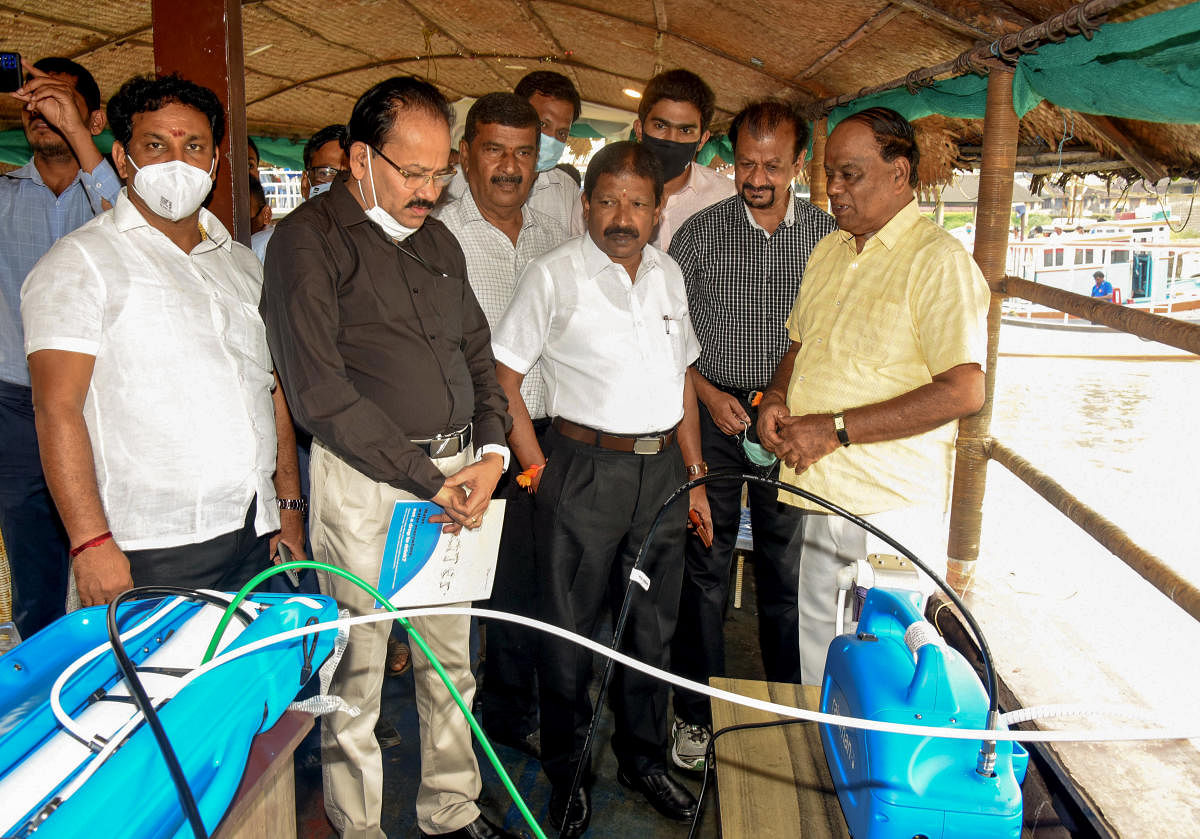 Minister for Fisheries, Port and Inland Water Transport S Angara looks at a demonstration of an Australian-based technology purifier turning saltwater into potable water in a boat while sailing from Bunder to Bengre in Mangaluru on Friday. DH photo