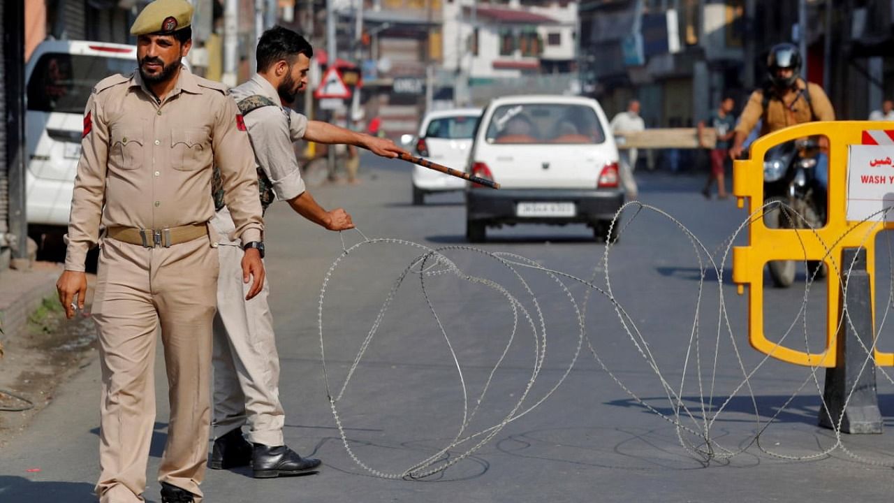 A policeman pulls concertina wire to close a road during restrictions imposed by authorities following the death of Syed Ali Shah Geelani, a Kashmiri veteran separatist politician, in Srinagar. Credit: Reuters photo