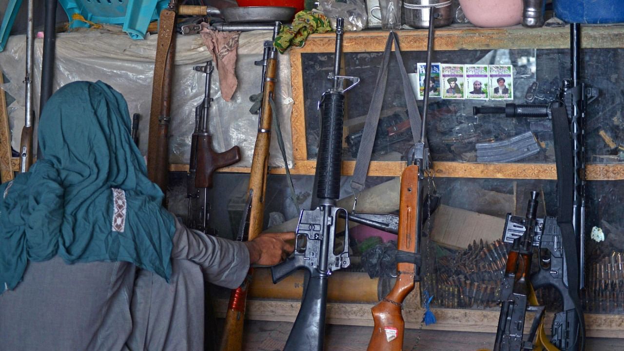 An Afghan vendor displays guns for sale as he waits for customers in his shop at a market in Panjwai district of Kandahar province. Credit: AFP Photo