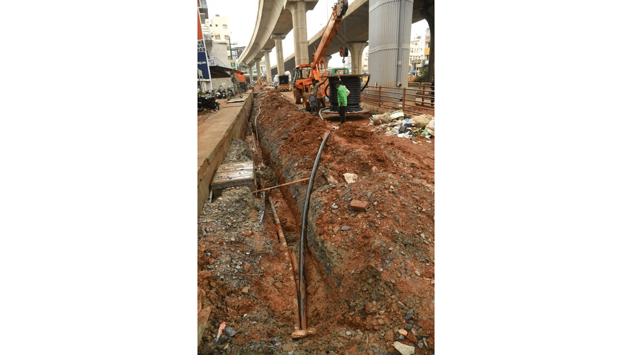 Bescom workers lay underground electric cables at T Dasarahalli. Work is on in full swing in various parts of the city. DH Photo/B H Shivakumar