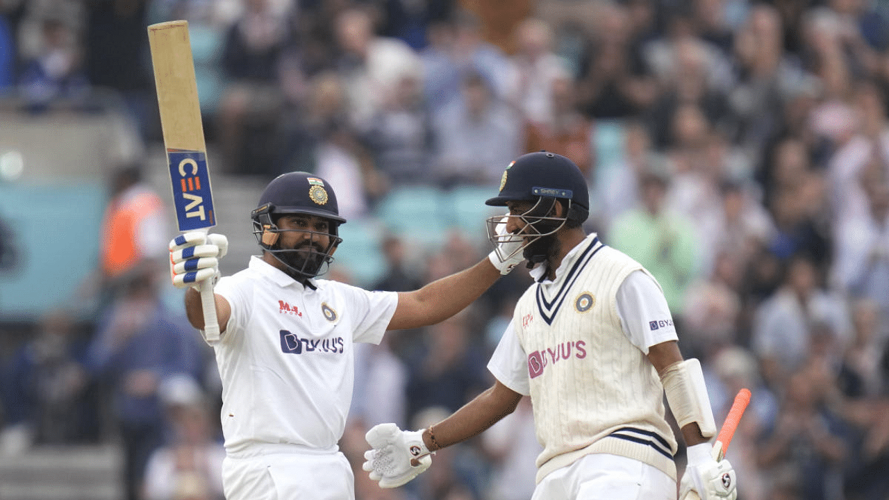 Rohit Sharma, left, celebrates scoring 100 runs with batting partner Cheteshwar Pujara on day three of the fourth Test match at The Oval cricket ground in London. Credit: AP Photo
