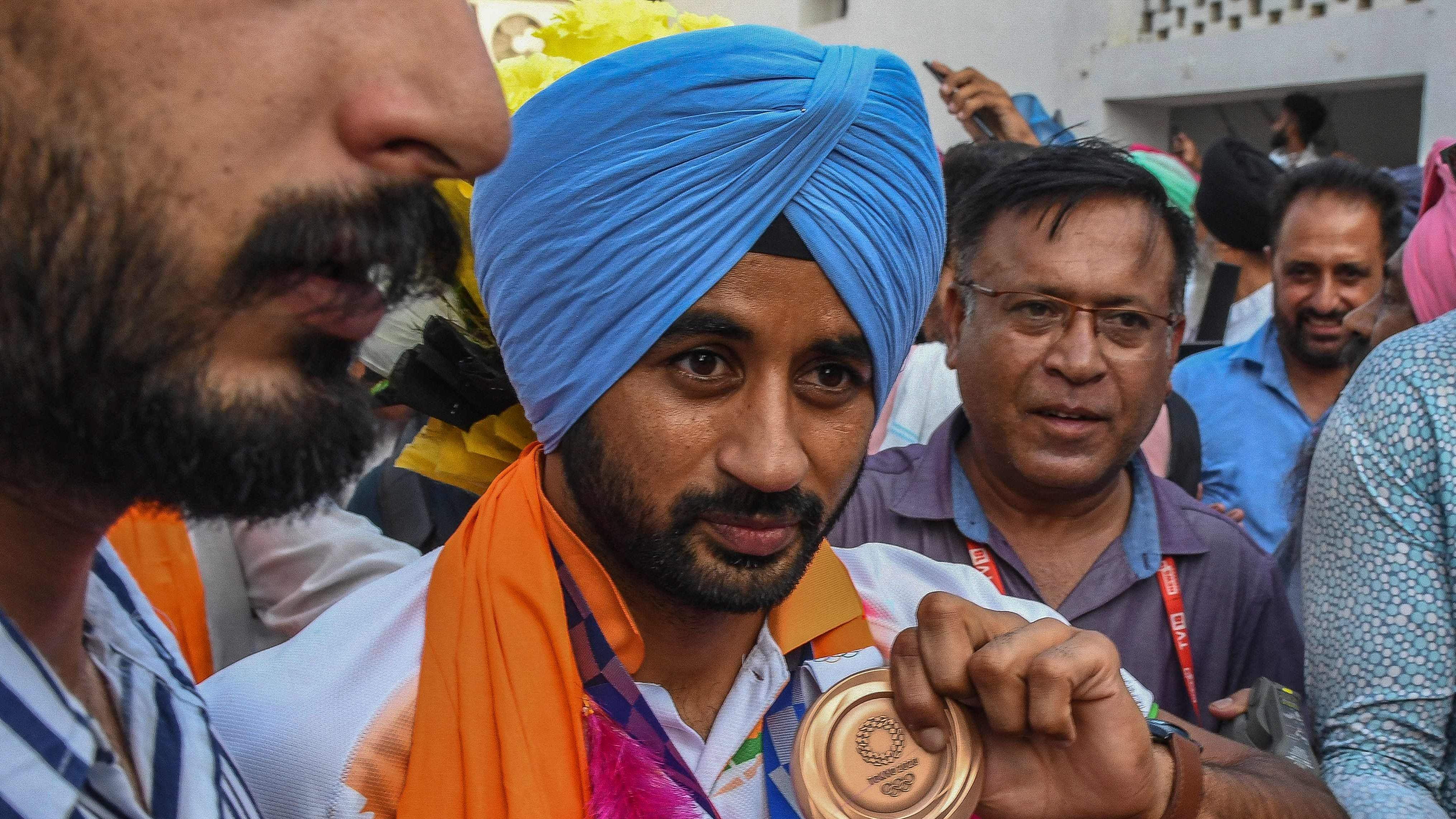 India's men's field hockey team captain Manpreet Singh (c) displays his Tokyo bronze medal. Credit: AFP File Photo