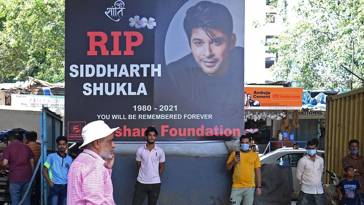 People stand in front of a poster of Indian actor Sidharth Shukla, after his demise in Mumbai. Credit: AFP Photo