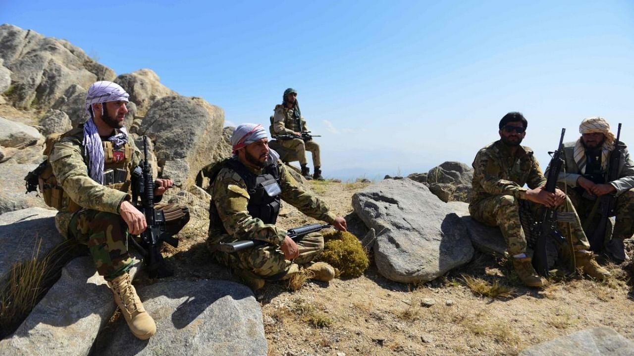 Afghan resistance movement and anti-Taliban uprising forces take rest as they patrol on a hilltop in Darband area in Anaba district, Panjshir province. Credit: AFP Photo