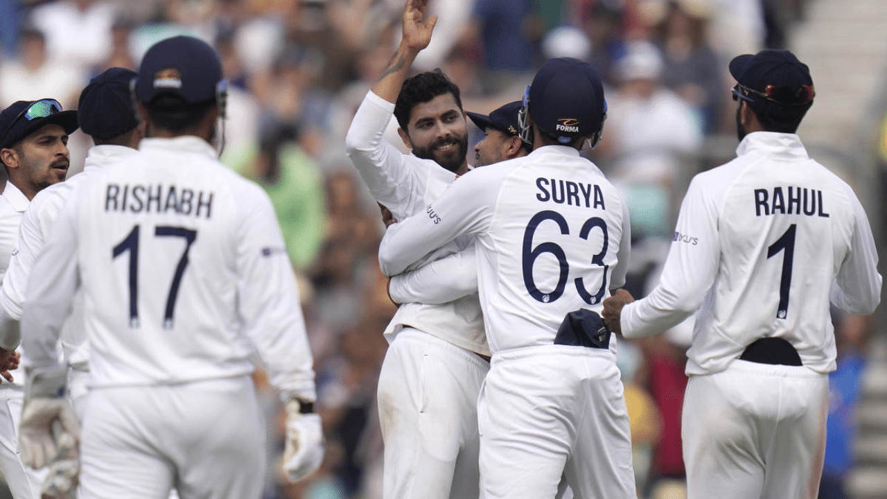 Ravindra Jadeja, centre, is hugged as he celebrates taking the wicket of England's Haseeb Hameed on day five of the fourth Test match at The Oval cricket ground in London. Credit: AP Photo