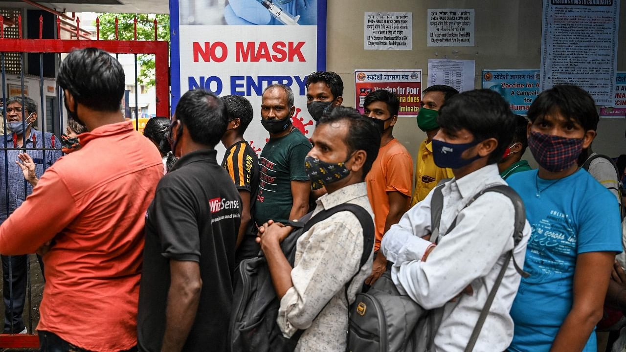 People queue up to get themselves inoculated with a dose of the Covaxin vaccine against the Covid-19 coronavirus, at a temporary vaccination centre set up inside a school in Mumbai on September 7, 2021. Credit: AFP Photo