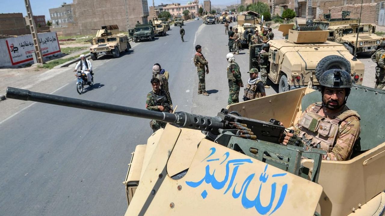 An Afghan National Army commando stands guard on top of a vehicle along the road in Enjil district of Herat province on August 1, 2021, as skirmishes between Afghan National Army and Taliban continues. Credit: AFP Photo