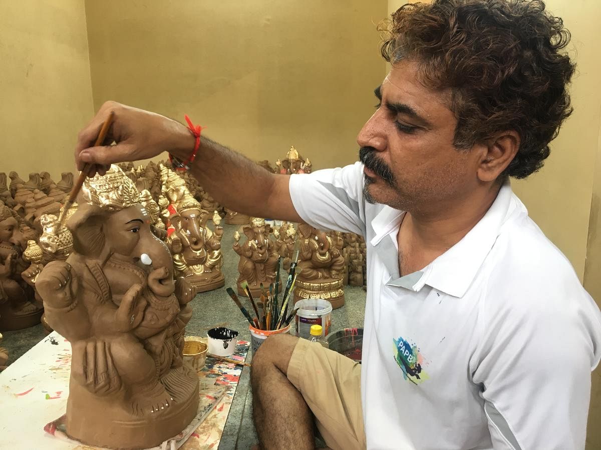 Lakshman Kabadi, owner of a stall at Geleyara Balaga Circle, Mahalakshmipuram, is selling plain and semi-coloured clay idols.