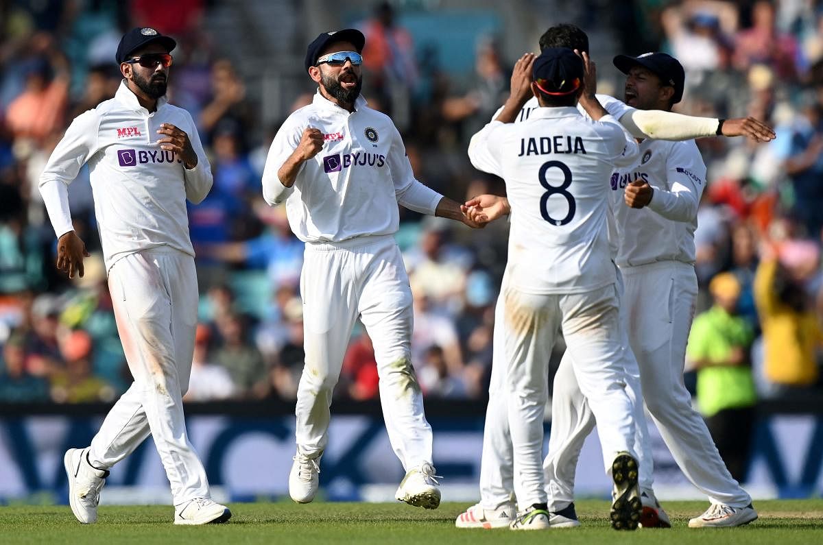 Virat Kohli (2L) celebrates the wicket of England's Craig Overton during play on the fifth day of the fourth cricket Test match. Credit: AFP Photo