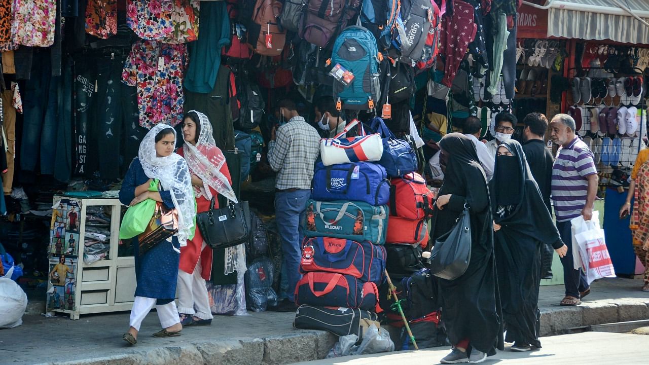 People shop at a market as life returns to normal after five days of restrictions following the death of Hurriyat Chairman Syed Ali Shah Geelani, in Srinagar, Tuesday. Credit: PTI Photo