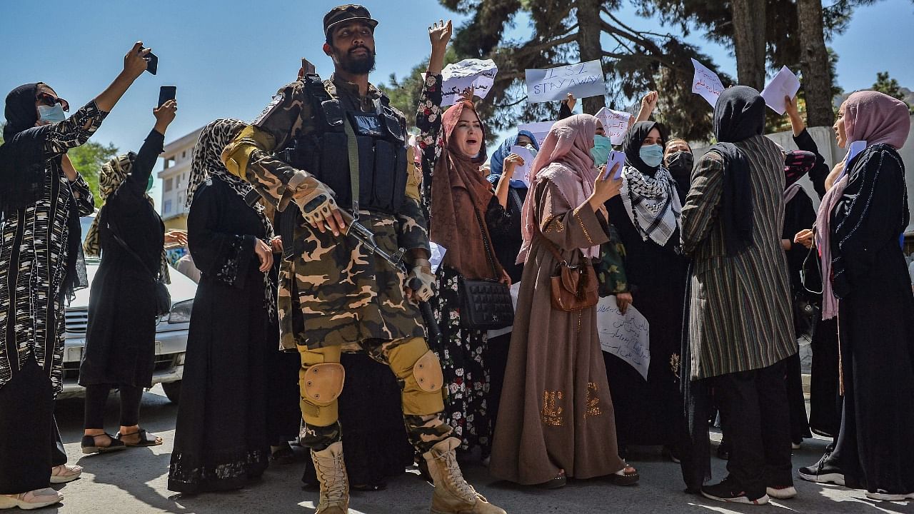 A Taliban fighter stands guard as Afghan women shout slogans during an anti-Pakistan protest rally, near the Pakistan embassy in Kabul on September 7, 2021. Credit: AFP Photo