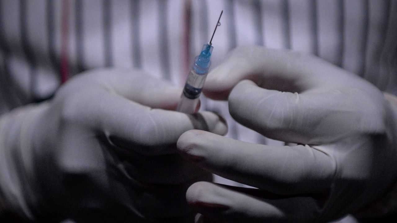 A health worker prepares a dose of Covishield vaccine against the Covid-19 coronavirus during a vaccination camp set up inside an auditorium in Vashi on September 8, 2021. Credit: AFP Photo