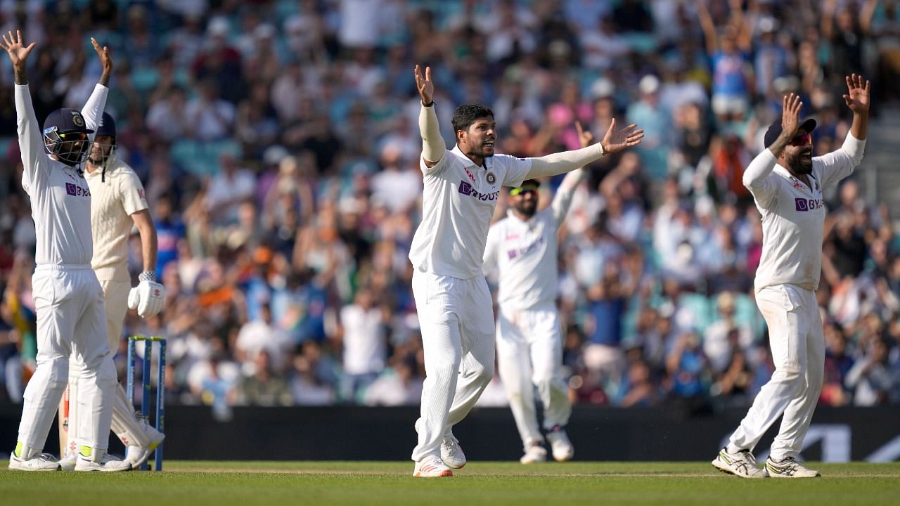  India's Umesh Yadav, centre, celebrates as he takes the wicket of England's James Anderson. Credit: AP/PTI Photo