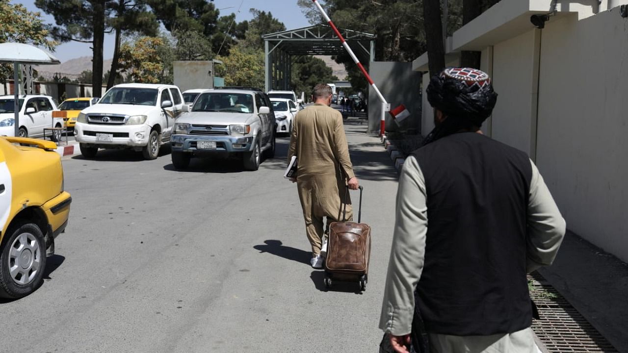 An Afghan man carries his suitcase to the international airport in Kabul, Afghanistan. Credit: Reuters Photo