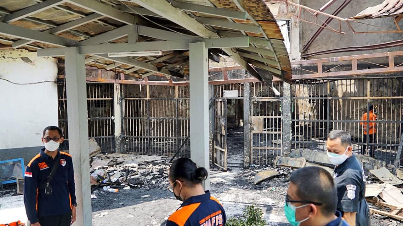 Police officers inspect damage cells after a fire at Tangerang Prison. Credit: AP Photo