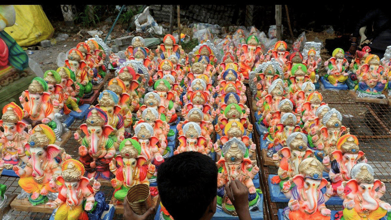 A boy paints idols of Lord Ganesha displayed for sale at a roadside stall ahead of the Ganesh Chaturthi festival in Hyderabad. Credit: AFP Photo