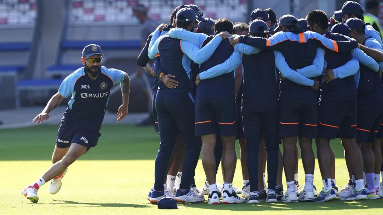 India's Virat Kohli, left, runs around a group huddle during the nets session at Old Trafford, Manchester, England, Wednesday Sept. 8, 2021 ahead of the fifth cricket test against England. Credit: AP/PTI photo