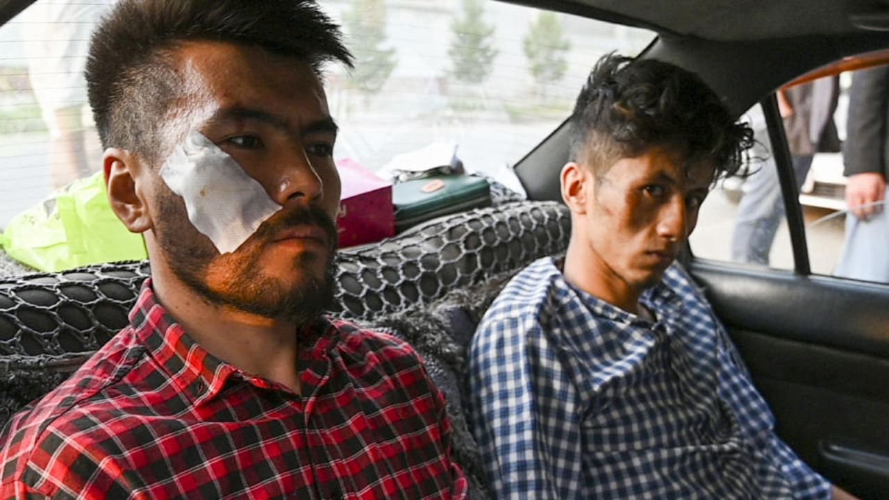 In this picture taken on September 8, 2021, Afghan newspaper Etilaatroz journalists Neamat Naqdi (L) and Taqi Daryabi arrive at their office after being released from Taliban custody in Kabul. Credit: AFP Photo