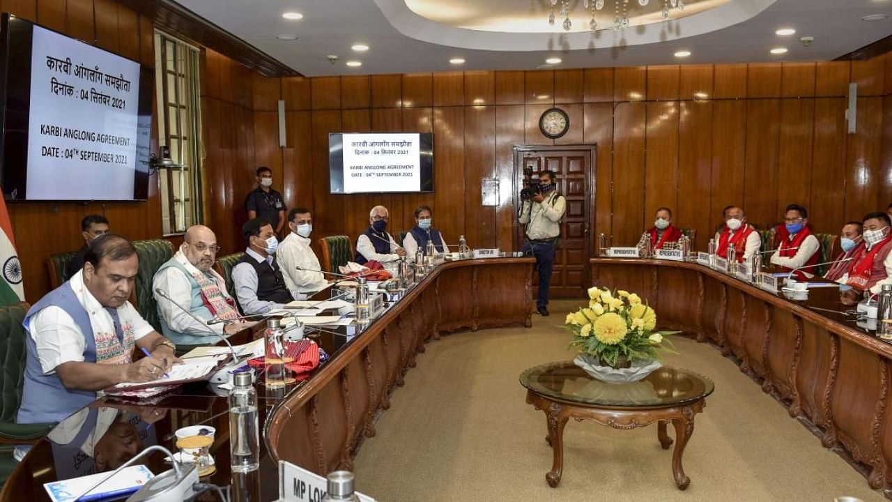 Home Miniser Amit Shah and others look on as Assam Chief Minister Himanta Biswa Sarma signs the Karbi Anglong Agreement, at North Block in New Delhi. Credit: PTI Photo