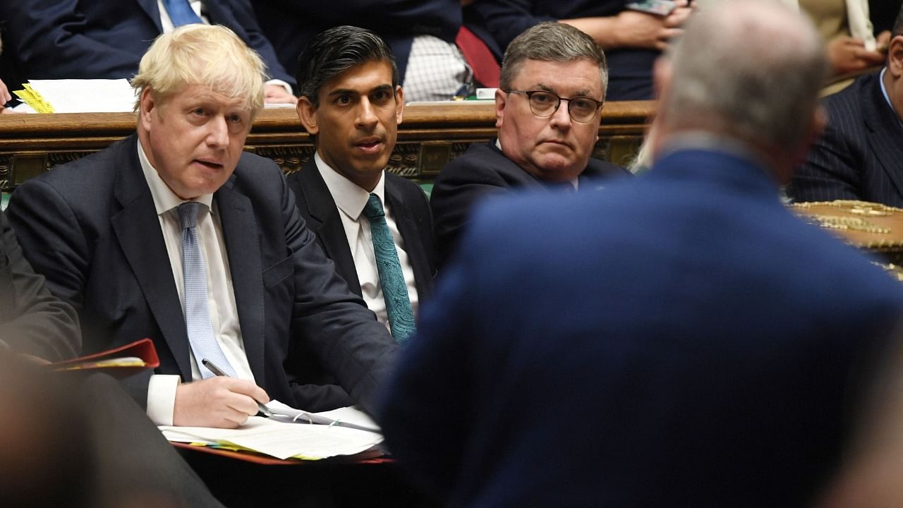 A handout photograph released by the UK Parliament shows Britain's Prime Minister Boris Johnson (L) and Britain's Chancellor of the Exchequer Rishi Sunak listens to a question during the weekly Prime Minister's Questions (PMQs) session in the House of Commons in London on September 8, 2021. Credit: Jessica Taylor/UK parliament/AFP 