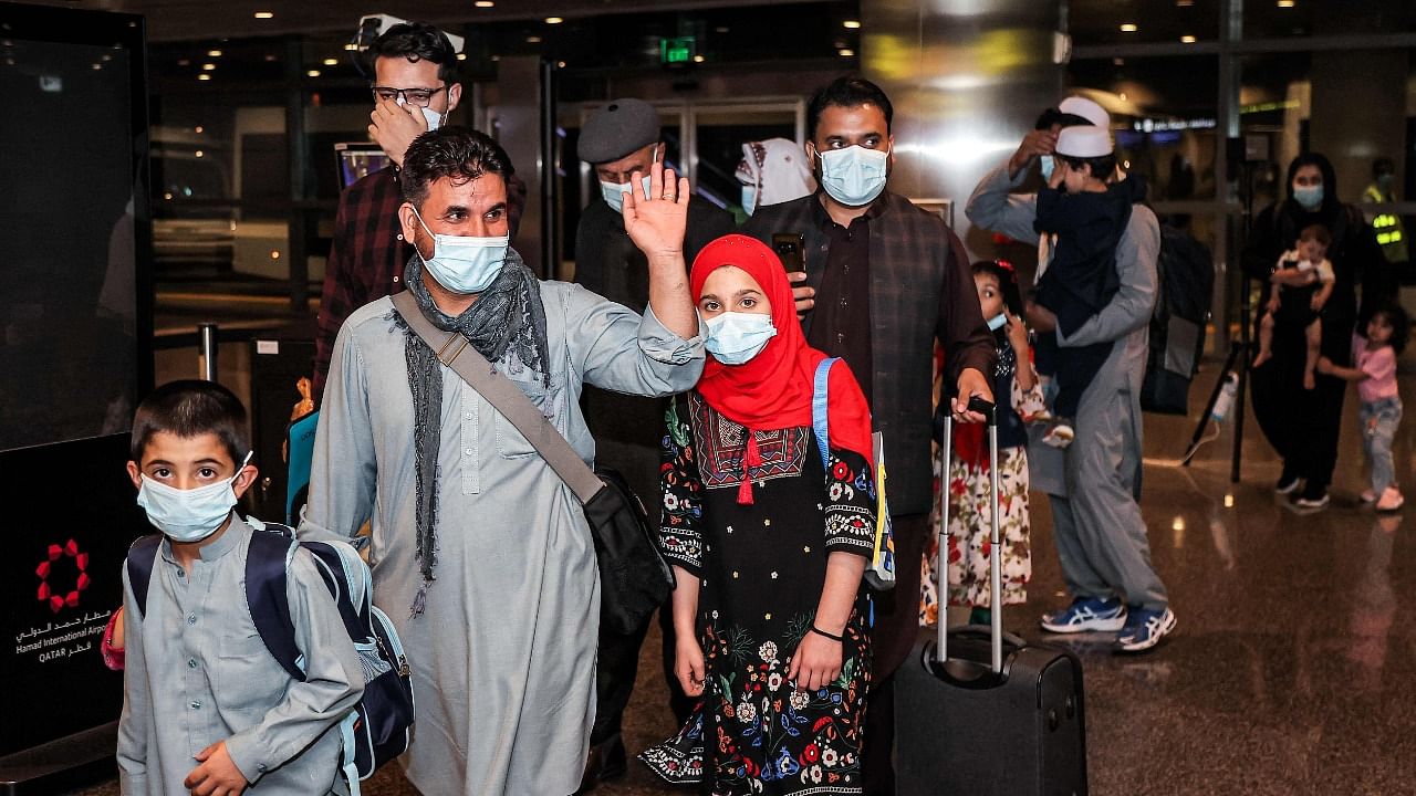 Evacuees from Afghanistan arrive inside the terminal at Hamad International Airport in Doha on the first flight carrying foreigners out of Kabul since the conclusion of the US pullout last month. Credit: AFP Photo