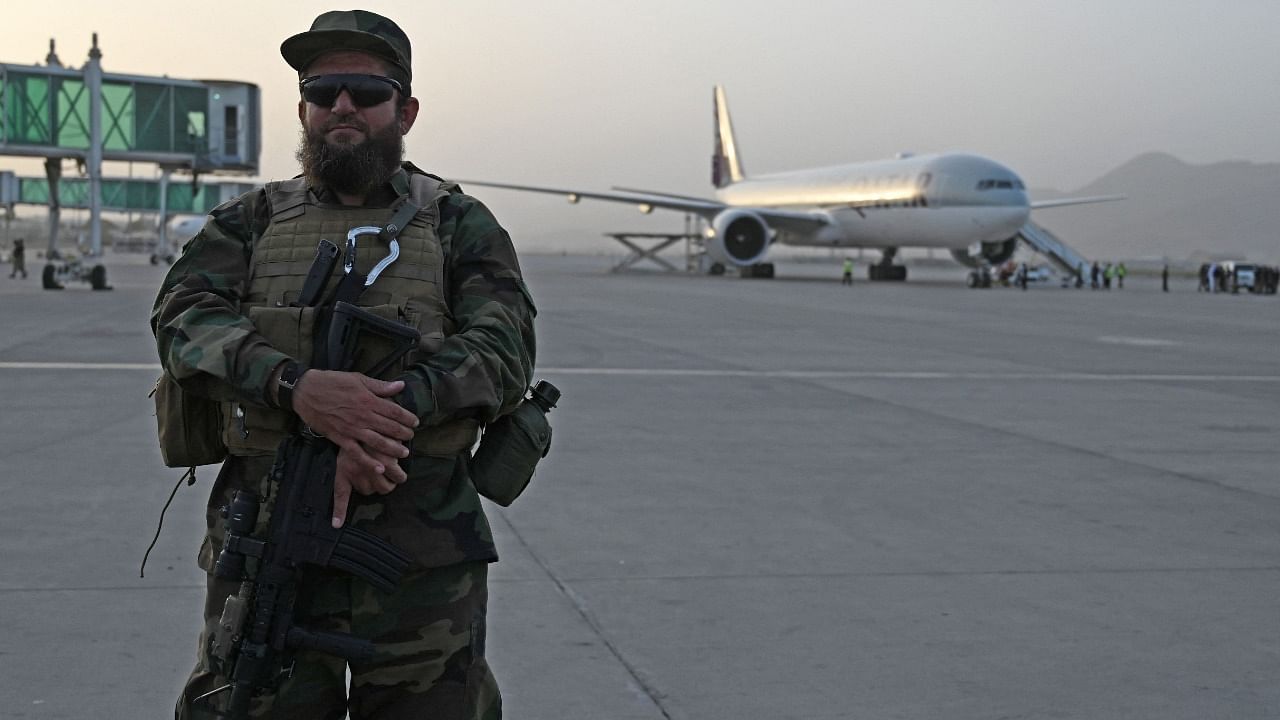 A member of the Taliban Badri 313 military unit stands guard as passengers board a Qatar Airways aircraft bound to Qatar at the airport in Kabul on September 10, 2021. Credit: AFP Photo