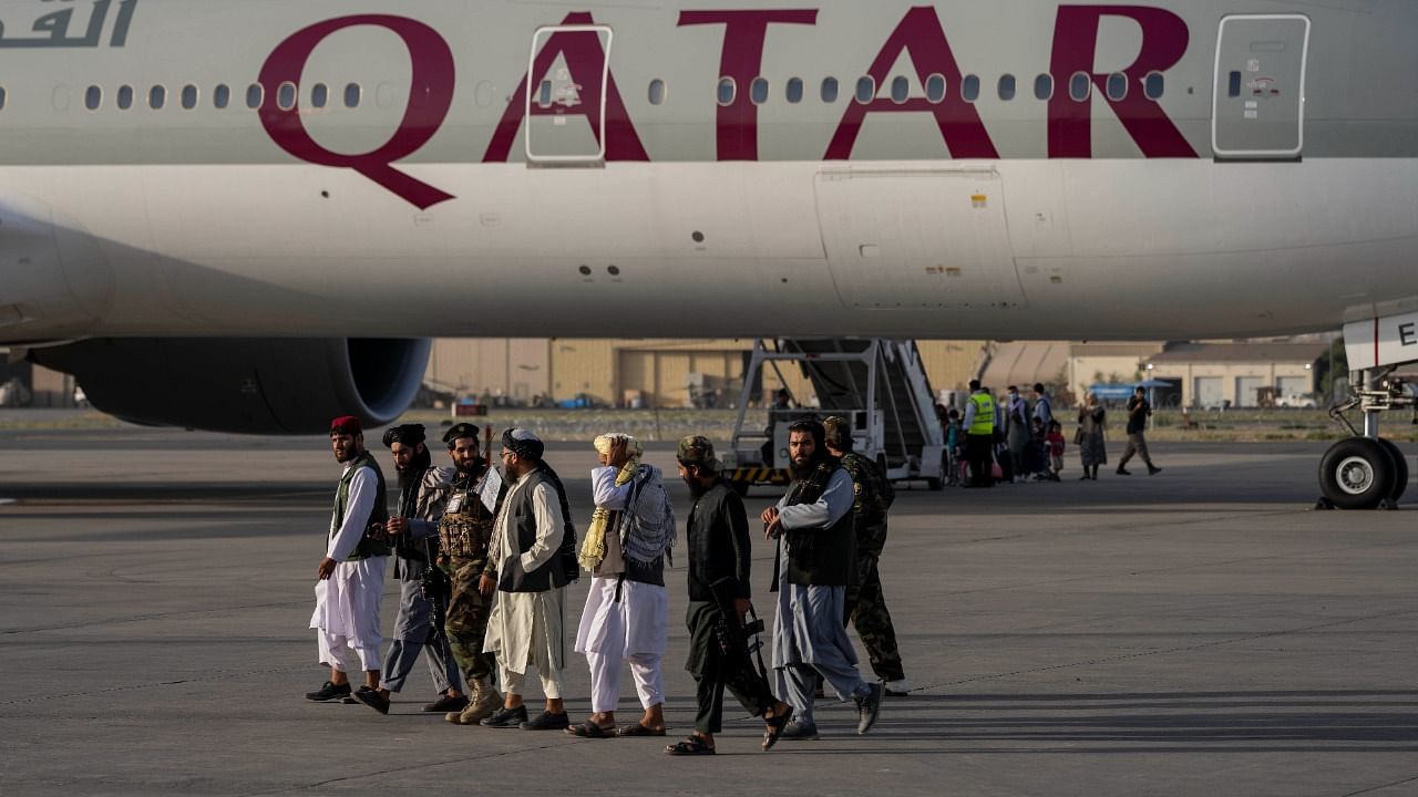 Taliban fighters walk past a Qatar Airways aircraft at the airport in Kabul, Afghanistan. Credit: AP/PTI Photo